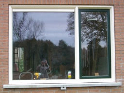 Nog een keuken kozijn met donkergroen draaikiep raam en een ventilatie rooster,