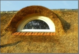 Halfrond kunststof raam op rieten dak in een dakkapel
