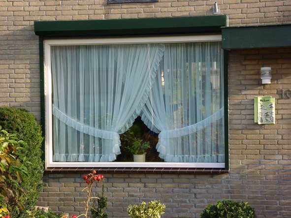 Huiskamer kozijn aan voorzijde woning met rolluik